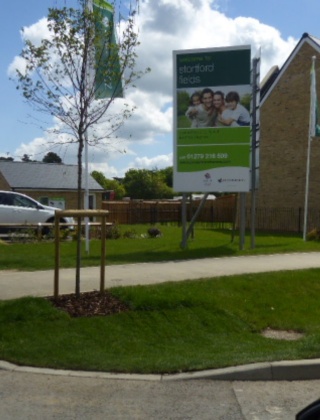 Promotion signage and flags next to a new housing development.