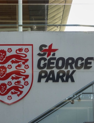 A concrete wall with the England Three Lions and St. George's Park logo on it.