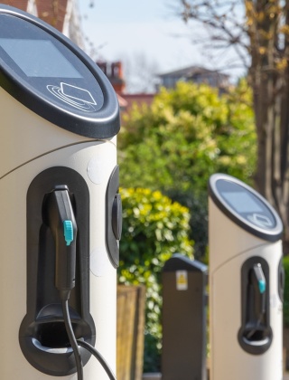 Three electric vehicle charging points along the side of a street.