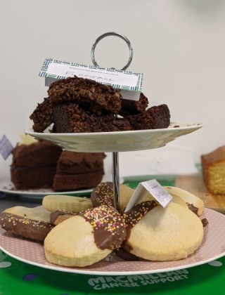 A close up image of cakes and biscuits at a bake sale.