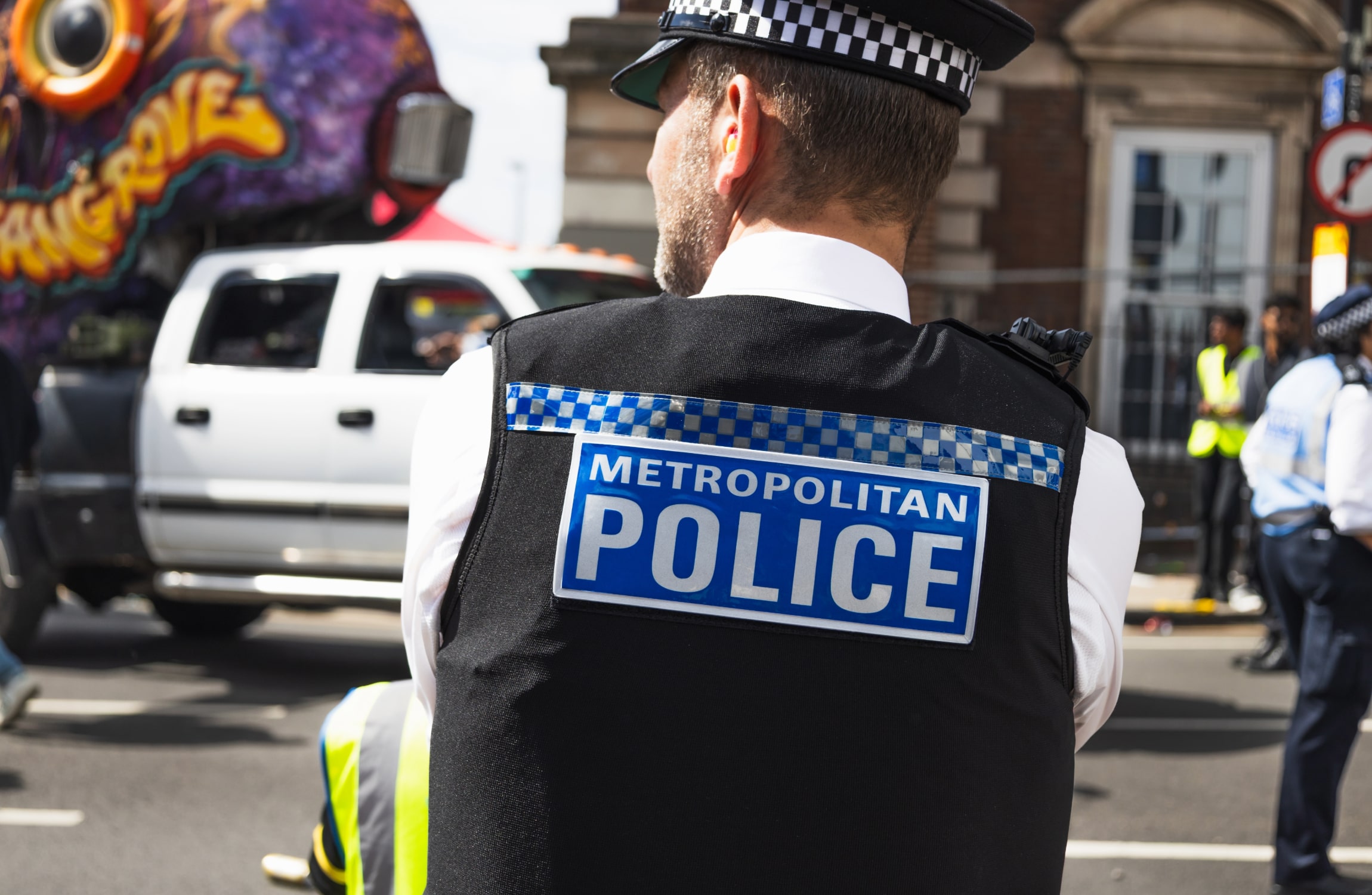 Police with backturned looking at a road.