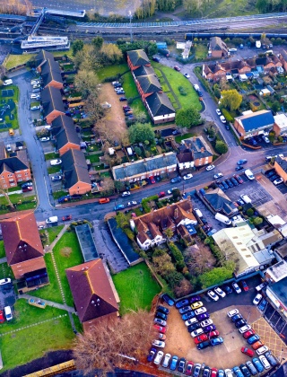 Aerial view of a busy housing estate, with a main road that runs through the middle of it.