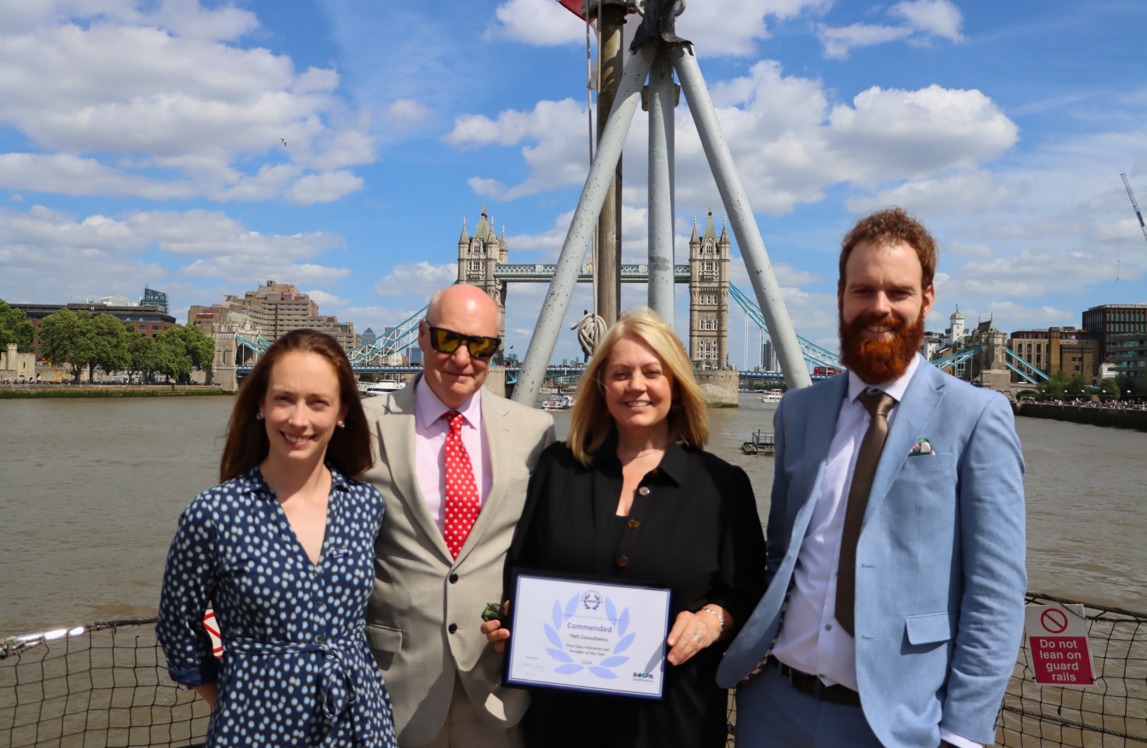 Jess Waldron (TMS), Steve Proctor (TMS), Tara Jowett (TMS) and Richard Cook (TMS) behind tower bridge and holding an award.