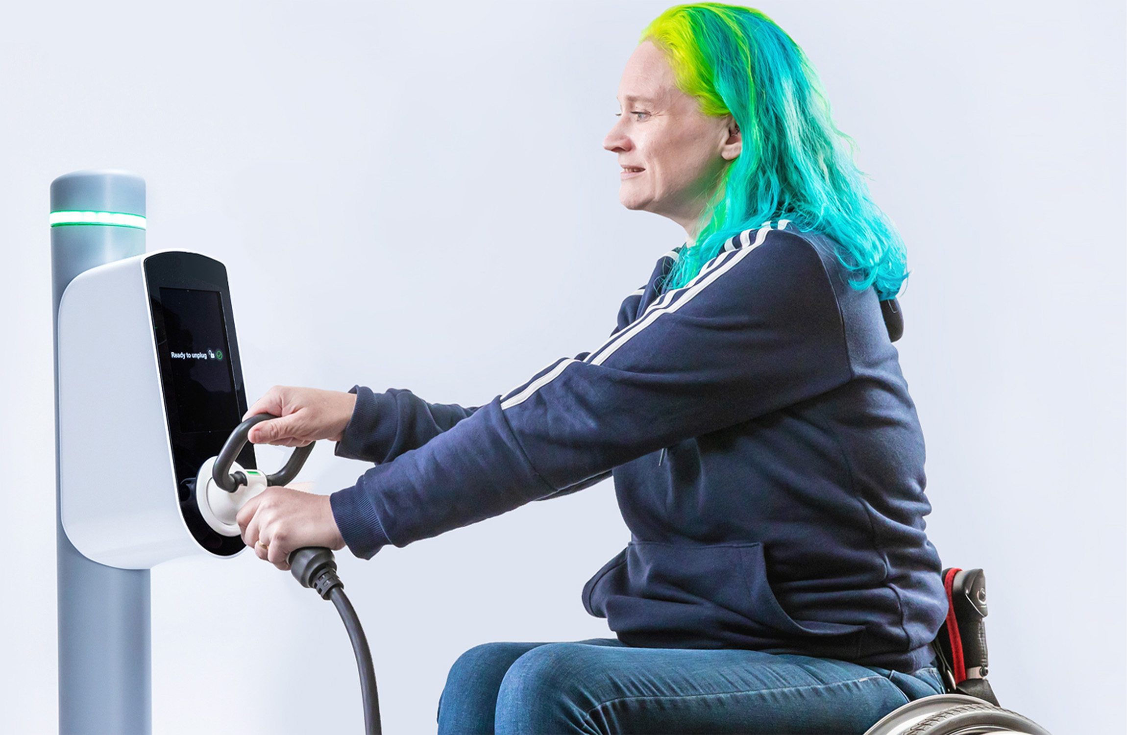 Disabled woman taking out the charger plug from an EV charger.