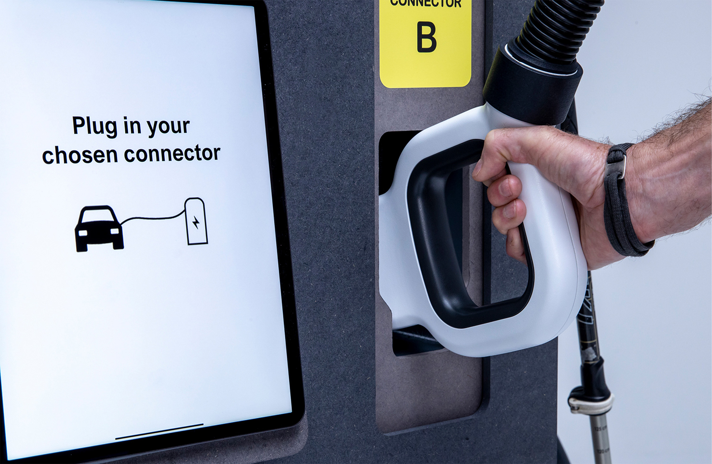 Hand taking out an EV charger plug.