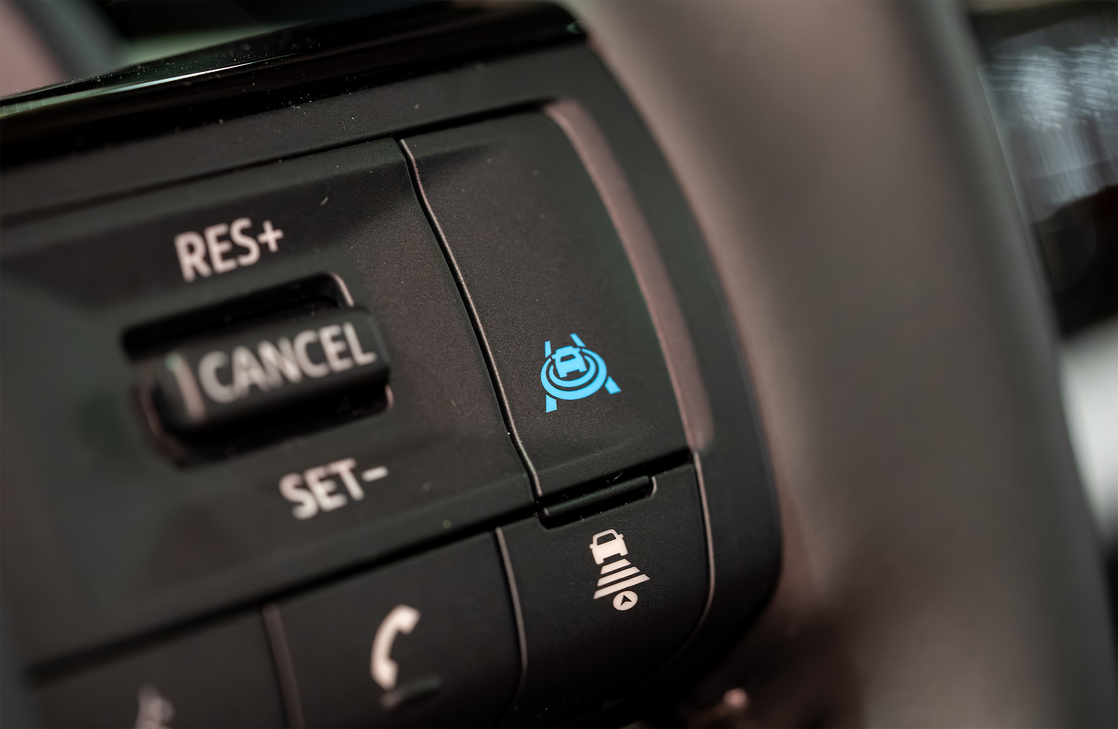 Zoomed in steering wheel to the lane assist button.